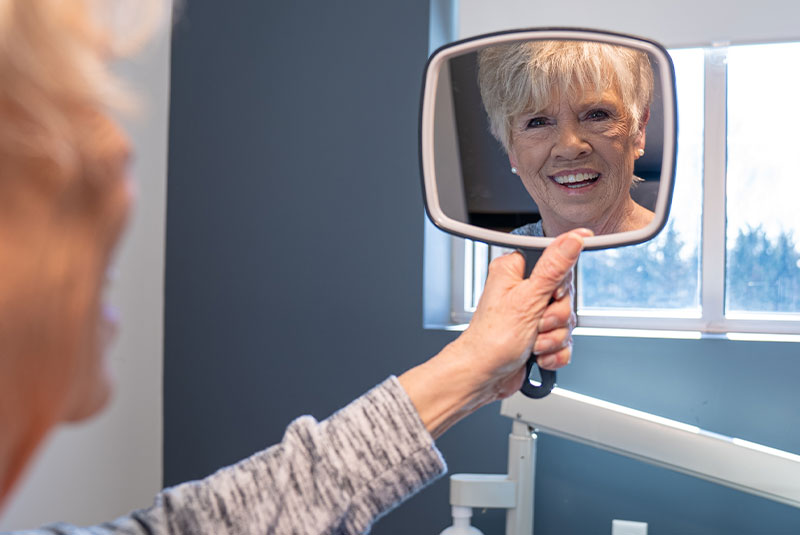 Patient smiling into mirror